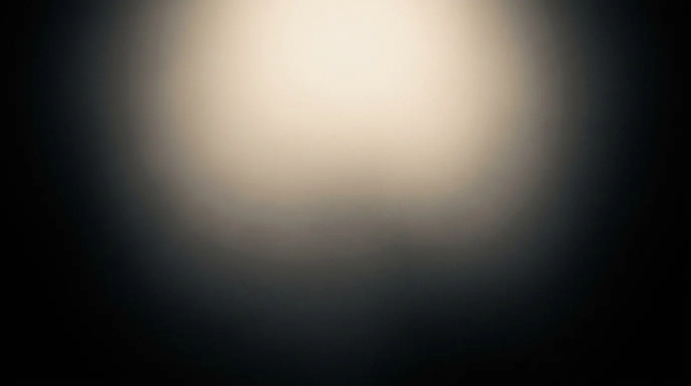 Soft warm light pooling on a charcoal surface